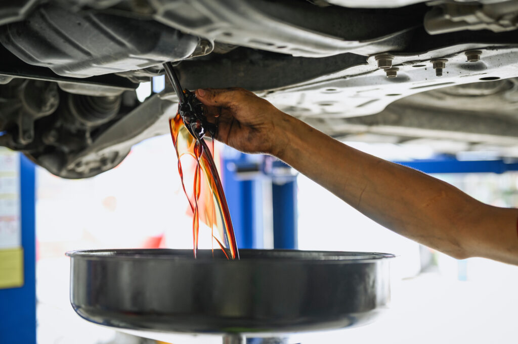 A car's oil, draining into an oil pan.