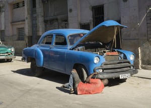 man works on classic car