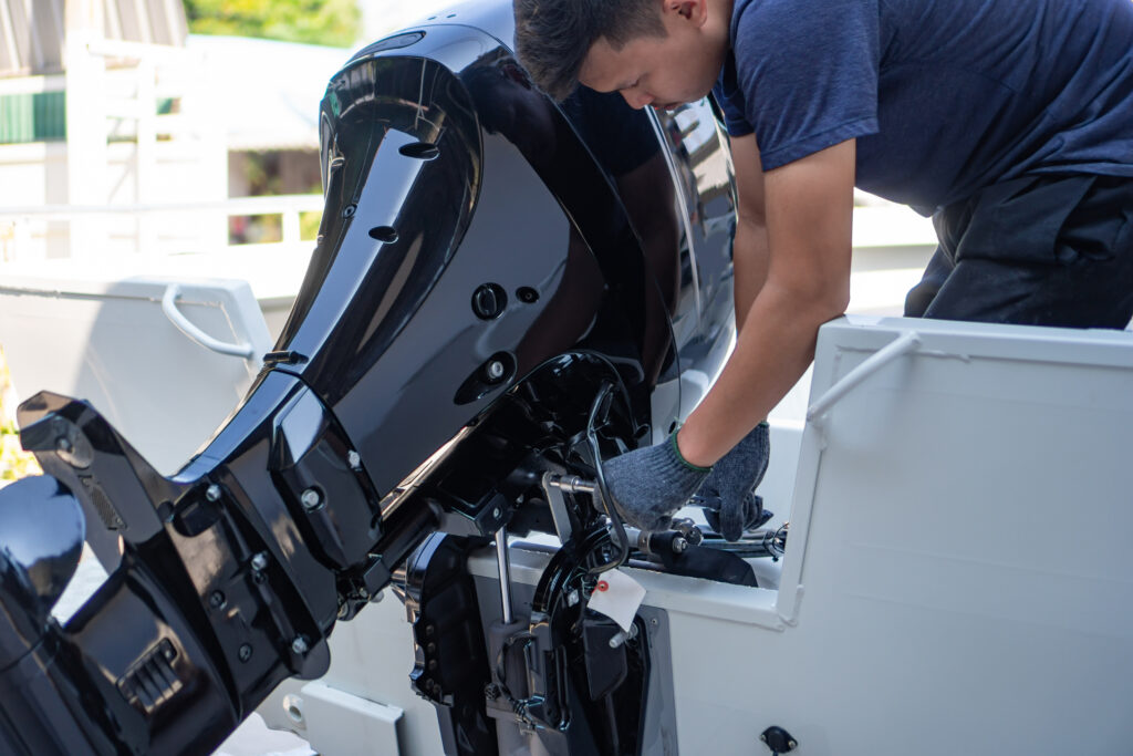 A technician performing maintenance on a boat's engine.