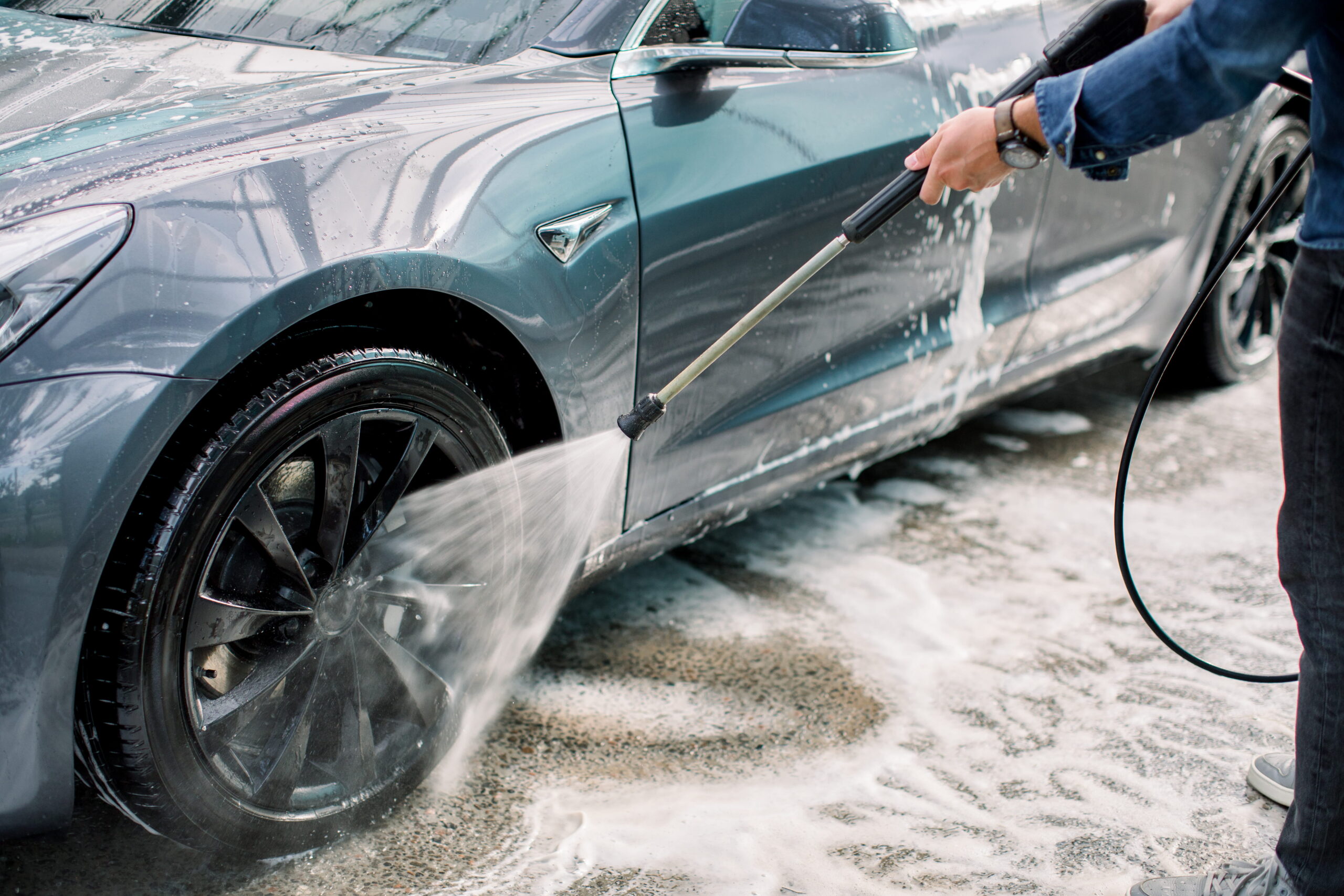 A car being cleaned with a water jet.