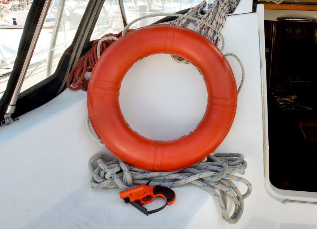 A flare gun and life preserver on a boat. 
