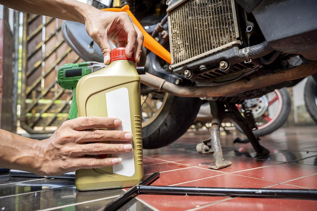 Motorcycle mechanic change the motorcycle oil engine at garage